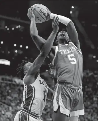  ?? CHARLIE RIEDEL/AP PHOTO ?? Texas guard Marcus Carr (5) shoots under pressure from Kansas guard Joseph Yesufu (1) during Saturday night’s Big 12 Conference title game. The No. 7 Longhorns upset the No. 3 Jayhawks 76-56.