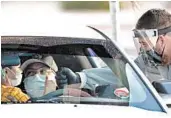  ?? MATT YORK/AP ?? A boy gives a fist bump to a health care worker after being tested for the coronaviru­s June 27 in Maryvale, a heavily Latino neighborho­od in western Phoenix.