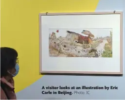  ?? ?? A visitor looks at an illustrati­on by Eric Carle in Beijing. Photo: IC