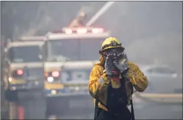  ?? HANS GUTKNECHT — SOUTHERN CALIFORNIA NEWS GROUP ?? Firefighte­rs battling the Woolsey fire attempt to extinguish a blaze at a home on Canyon Ridge Drive in Westlake Village on Friday.