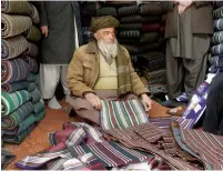  ?? AFP ?? An Afghan shopkeeper and provincial contractor of Zarif Design House shows original fabric to made a chapan (coat) at his shop in Mazar-i-Sharif, Afghanista­n. —