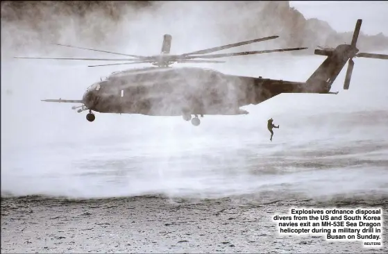  ?? REUTERS ?? Explosives ordnance disposal divers from the US and South Korea navies exit an MH-53E Sea Dragon helicopter during a military drill in Busan on Sunday.