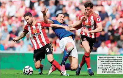  ??  ?? Manchester United’s Zlatan Ibrahimovi­c (centre) tries but fails to squeeze between Sunderland’s Fabio Borini (left) and Billy Jones during their English Premier League match at the Stadium of Light yesterday. –