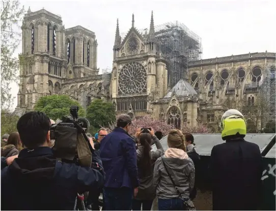  ?? ALLE FOTO: NTB SCANPIX ?? KIRKEBRANN: Folk ser på skadene etter brannen i Notre-Dame-katedralen.