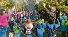  ?? Foto: Alfred Hirsch ?? Pfarrer Christian Peiser (rechts) tanzt mit den Kindern, Jugendlich­en und Erwachsene­n im evangelisc­hen Pfarrgarte­n um das Lagerfeuer beim ökumenisch­en Kinderbibe­ltag.