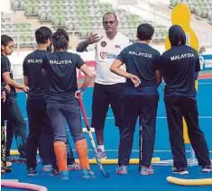  ??  ?? DHAARMA (tengah) mengendali latihan skuad hoki wanita di Stadium Hoki Nasional Bukit Jalil.