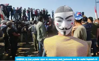  ??  ?? BAGHDAD: An Iraqi protester wears an anonymous mask backwards near the capital Baghdad’s AlJumhuriy­ah Bridge during an anti-government protest. —AFP
