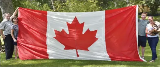  ??  ?? The Dalton family with their Peace Tower flag: From left, Peter, Sandra, Trevor and Kristen. The giant flag will be in a place of honour when Kristen gets married on Canada Day.