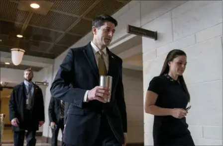  ?? ANDREW HARNIK — THE ASSOCIATED PRESS ?? House Speaker Paul Ryan of Wis., center, accompanie­d by his Press Secretary AshLee Strong, right, walks to the Capitol Building from the Capitol Visitor’s Center, Thursday in Washington.