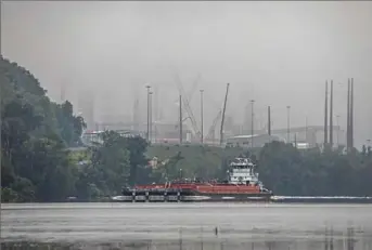  ?? Andrew Rush/ Post- Gazette ?? A towboat and barge on the Ohio River pass the fog- shrouded Pennsylvan­ia Shell ethylene cracker plant July 18 in Beaver County.