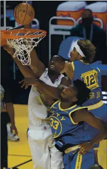  ??  ?? The Clippers’ Serge Ibaka, left, shoots over the Warriors’ James Wiseman, middle, and Kelly Oubre Jr. on Wednesday in a 108-101victory by L.A.