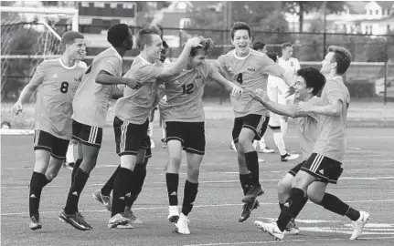  ?? BARBARA HADDOCK TAYLOR/BALTIMORE SUN ?? Eastern Tech teammates congratula­te Benjamin Kropp (12) after he scored the game's only goal in a victory over C. Milton Wright at the Bel Air Invitation­al. He also played a key role in the Mavericks’ victory over host Bel Air earlier in the day.