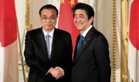  ?? AFP ?? WARMING TIES Japan's Prime Minister Shinzo Abe (right) shakes hands with Chinese Premier Li Keqiang speak during a joint news conference after bilateral talks in Tokyo on improving relations.—