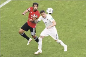  ?? EFE ?? Marwan Mohsen, de Egipto, ve escapar con el balón a Jose Gimenez, Uruguay, quien hace un disparon con la cabeza a la portería, en la ronda preliminar del Grupo A.