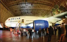  ?? HYOSUB SHIN / HSHIN@AJC.COM ?? Former and current employees of Delta Air Lines were invited to a farewell tour of a Delta 747 at Delta TechOps on Tuesday. Delta CEO Ed Bastian said the 747 is less fuel efficient and costs more to maintain than newer planes.