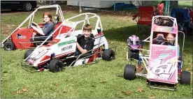  ?? PHOTOS BY JESI YOST - FOR MEDIANEWS GROUP ?? Montgomery County Quarter Midget Racing Club drivers and their cars, from left, Piper Fryer, 16, “The Red Menace Fryer;” Aleks McIlroy, 13, “Pretty Boy McIlroy” and Evelina McIlroy, 9, “Lite Bright.”