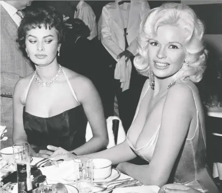  ?? JOE SHERE/ MPTVIMAGES.COM ?? What was Sophia Loren, left, really thinking as she sat next to Jayne Mansfield during a glitzy party in 1957? “Look at the picture. Where are my eyes? I'm staring at her nipples because I am afraid they are about to come on to my plate,” Loren admitted in 2014.