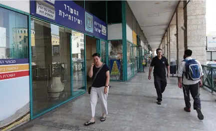  ?? (Marc Israel Sellem/The Jerusalem Post) ?? PEOPLE WALK past the Religious Services Ministry office in Jerusalem. At most, this week’s High Court ruling widens the scope of who can become an Israeli through immigratio­n.