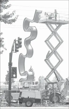  ?? LARRY MCCORMACK/THE TENNESSEAN ?? Light Meander, a sculpture by artists Laura Haddad and Tom Drugan and made using used guitar picks, LED lights, stainless steel and ipe wood, is shown under constructi­on in Nashville. The immense structure’s bends and curves reflect the shape of the...