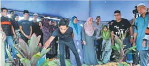  ?? — Gambar Bernama ?? DISEMADI: Anak Allahyarha­m Ramli Abdul Majid, Muhammad Fauzi Ramli, 17, menyiram air di pusara bapanya pada majlis pengkebumi­an di Tanah Perkuburan Batu 14 di Puchong dekat Kuala Lumpur, semalam.