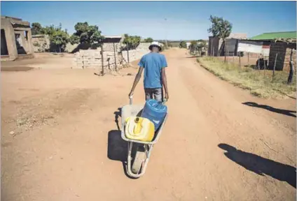  ?? Photo: Delwyn Verasamy ?? Shortage: A teen fills containers with water for older residents in Verena, Mpumalanga. Many households in South Africa don’t have piped water and municipali­ties lose 40% through leakages.