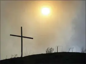  ?? LAURA PASKUS VIA AP ?? This shows the silhouette of a cross amid smokey skies on May 4where hundreds of firefighte­rs are battling a massive wildfire burning in the Sangre de Cristo Mountains near the community of Las Vegas, New Mexico.