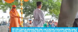  ??  ?? EAST ACEH: A Sharia law enforcemen­t official whips a man in East Aceh, in Aceh province yesterday. A group of men were publicly whipped for breaking Islamic law in Indonesia’s Aceh in front of a jeering crowd for being involved in online gambling. — AFP
