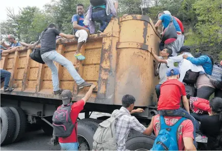  ?? PHOTOS / AP ?? Above: Honduran migrants bound to the US border climb into the bed of a truck in Zacapa, Guatemala. Left: Honduran migrants are taken care of by Guatemalan Red Cross volunteers, in Tecun Uman, Guatemala.