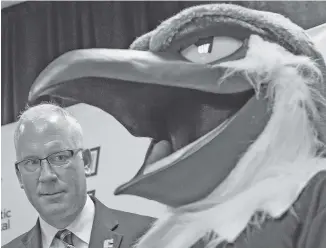  ?? STAFF PHOTO BY DOUG STRICKLAND ?? New UTC athletic director Mark Wharton meets Mocs mascot Scrappy after Wharton’s introducto­ry news conference Wednesday.