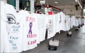  ?? NICK HILLEMANN/RIVER VALLEY & OZARK EDITION ?? The Arkansas Coalition Against Domestic Violence Clotheslin­e Project was on display at the fire station in downtown Conway and later on the lawn of the adjacent Faulkner County Courthouse. The 226 hand-decorated T-shirts represent women in Arkansas who were killed in the past 10 years by an intimate partner, according to the organizati­on’s website. The women’s names and stories are printed on the T-shirts. Twentieth Judicial District Judge H.G. Foster said he and others hope to get the T-shirts representi­ng women who were killed in Faulkner County more than 10 years ago and place the shirts on permanent display.