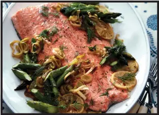  ?? COURTESY OF DANE TASHIMA — SIMON & SCHUSTER ?? Lidey Heuck's recipe for slow-roasted salmon is served with lemony leeks and asparagus.