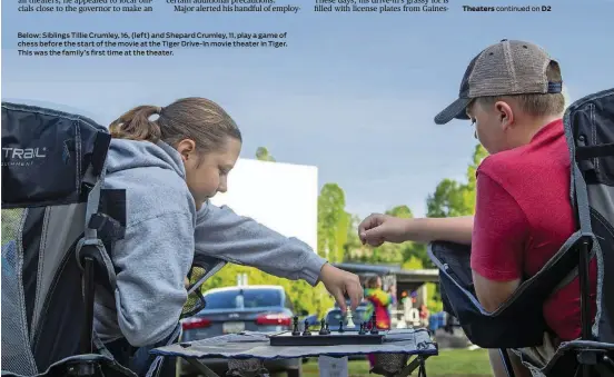  ??  ?? Below: Siblings Tillie Crumley, 16, (left) and Shepard Crumley, 11, play a game of chess before the start of the movie at the Tiger Drive-In movie theater in Tiger. This was the family’s first time at the theater.