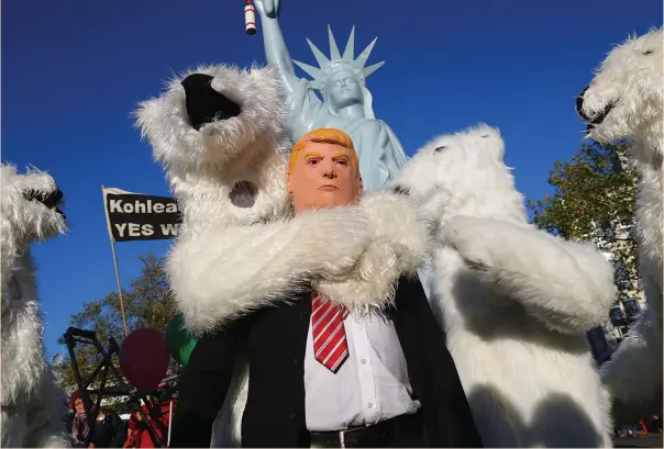  ?? (Reuters) ?? A PROTESTER wearing a mask of US President Donald Trump stands along with other demonstrat­ors dressed as polar bears during a protest under the banner ‘Protect the climate – stop coal’ two days before the start of the COP 23 UN Climate Change Conference.