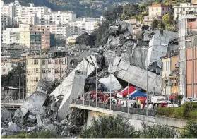  ?? Luca Zennaro / Associated Press ?? Rescuers work to recover an injured person after the Morandi highway bridge collapsed in Genoa, Italy, during a violent storm on Tuesday.