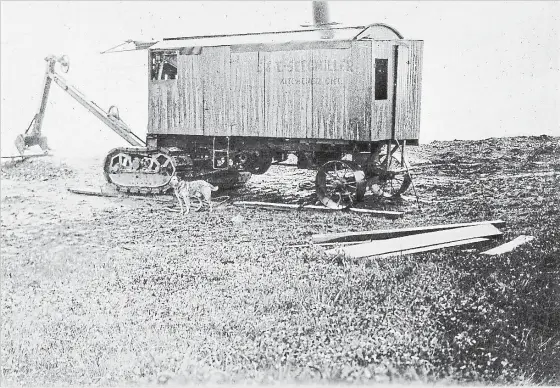  ?? PHOTO BY HOMER SNYDER, COURTESY RITA THOMPSON ?? Theft and vandalism were problems for contractor­s even back in 1927, so a guard dog was tethered to E &amp; E Seegmiller’s new steam shovel. The steam engine was in the rear of the unit and it powered the barely-visible cables running to the arms and bucket.