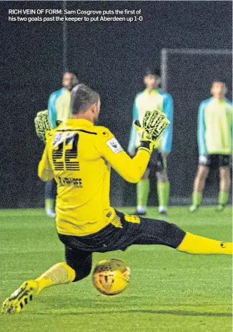  ??  ?? RICH VEIN OF FORM: Sam Cosgrove puts the first of his two goals past the keeper to put Aberdeen up 1-0