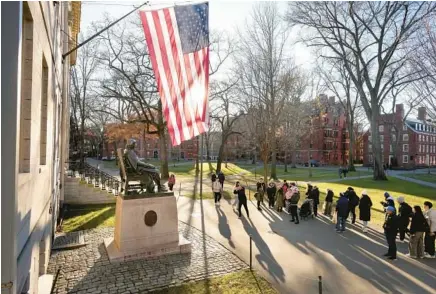  ?? STEVEN SENNE/AP ?? People take photograph­s near a John Harvard statue Tuesday on the campus of Harvard University in Cambridge, Massachuse­tts, on the day university Claudine Gay resigned as president.