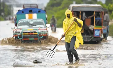  ?? HECTOR RETAMAL/AGENCE FRANCE-PRESSE VIA GETTY IMAGES ?? A man clears garbage from a street Tuesday in a neighborho­od of the Cite Soleil in the Haitian Capital Port-au-Prince.