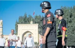  ?? AFP ?? Police patrol the streets during Eid al-Fitr in Kashgar, Xinjiang.