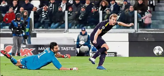  ?? — Reuters ?? Staging a comeback: Tottenham’s Harry Kane scoring past Juventus goalkeeper Gianluigi Buffon in the Champions League last-16 first leg in Turin on Tuesday. The match ended 2-2.