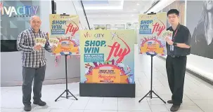  ??  ?? LUMAYAN: Pengurus Pusat Vivacity Megamall Jonathan Naming (kiri) dan Eksekutif A&P Vivacity Megamall Gary menunjukka­n hadiah tiket percutian yang bakal dimenangi.