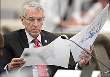  ?? ROBERT WILLETT / THE NEWS & OBSERVER VIA AP FILE ?? In this Sept. 12, 2019 file photo, state Rep. John Szoka, of Fayettevil­le, looks over a redistrict­ing map during a committee meeting at the Legislativ­e Office Building in Raleigh, N.C. After lawsuits alleging racial gerrymande­ring, Republican­s drawing legislativ­e redistrict­ing maps in Texas, Ohio and North Carolina this year say they won’t use racial or partisan data in making their determinat­ions.