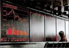  ?? AP ?? A man sits Monday in front of an electronic board displaying stock prices at a brokerage house in Beijing. China’s stock market has fallen close to levels last seen in a financial scare three years ago.