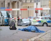  ??  ?? A body lies on a road Wednesday after the person was shot by an unidentifi­ed man who was eventually arrested.