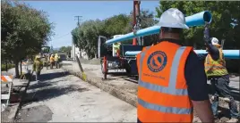  ??  ?? Cal Water employees oversee a new main line installati­on in Menlo Park, Calif., to improve firefighti­ng capabiliti­es and water system reliabilit­y.