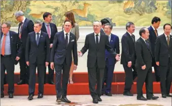  ?? ZOU HONG / CHINA DAILY ?? As they gather for a group photo at the Diaoyutai State Guesthouse in Beijing on Monday, Vice-Premier Liu He (center), European Commission Vice-President Jyrki Katainen (third from left in front row) and Chinese and EU officials attend the 7th China-EU...