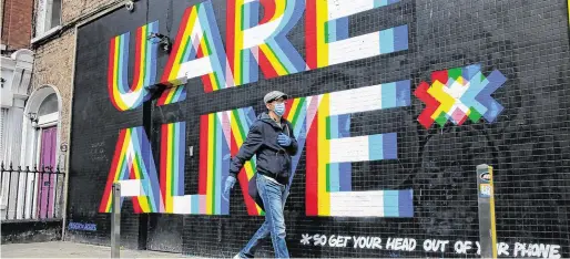  ?? PHOTO:GARETH CHANEY/COLLINS ?? Message: A pedestrian passes a mural in Dublin city centre during the Covid-19 lockdown