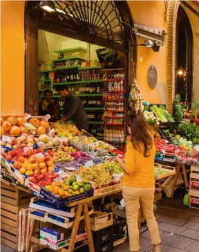  ?? ?? Left to right: the iconic red rooftops of Bologna, EmiliaRoma­gna; an artisanal shop in Bologna’s historic centre