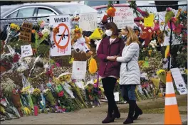  ?? DAVID ZALUBOWSKI — THE ASSOCIATED PRESS ?? Mourners on Thursday walk along the temporary fence put up around the parking lot of a King Soopers grocery store where a mass shooting took place in Boulder, Colo.