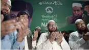  ?? AFP ?? The head of militant organsiati­on Jamaat- ud- Dawa Hafiz Saaed along with his newly formed political party AllahhuAkb­ar Tehreek nominated candidate Chaudhry Saeed Ahmed ( 2L) pray during the inaugurati­on ceremony of their election office in Islamabad.